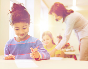 Obraz na płótnie Canvas happy little school girl over classroom background