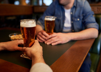 close up of men drinking beer at bar or pub
