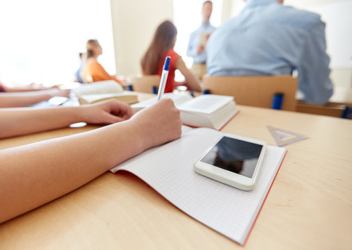 student with smartphone and notebook at school - Powered by Adobe