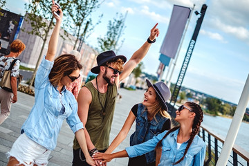 Friends put hands together and laugh