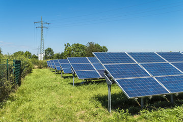 Stromtrasse und Photovoltaikanlage auf grüner Wiese