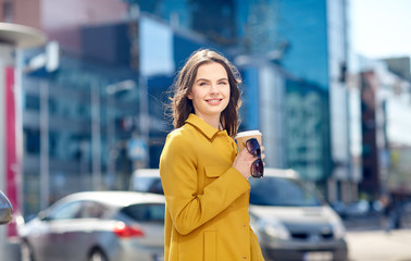 Fototapeta premium happy young woman drinking coffee on city street