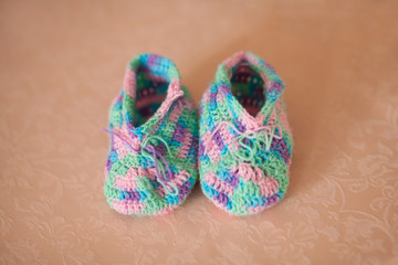 Knitted baby booties on a sofa, hand made