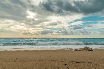 Wave spray splash over beach at blue sea