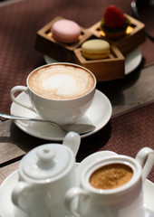 Cup of cappuccino and macaroons