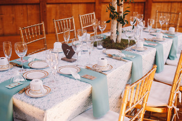 Wooden table number stands on the white lace tablecloth with bly