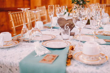 White plate with golden design stands on the blue serviette befo