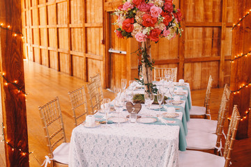 Fototapeta na wymiar Long blue dinner table stands in the wooden hangar prepared for