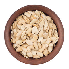 Pumpkin seeds in bowl isolated on white.