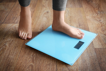 Female bare feet standing on a scales