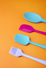 Colorful cooking utensils arranged on an orange background forming a page border