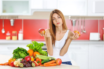 Woman choosing between croissant and apple