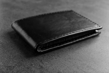 Black leather wallet on grey background