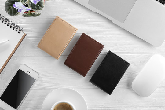 Stylish workplace with leather wallets on wooden table