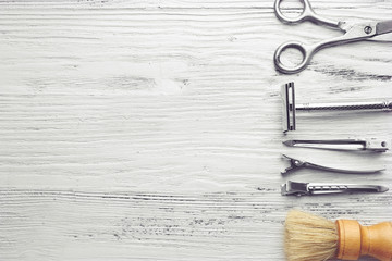 Vintage tools of barber shop on light wooden background