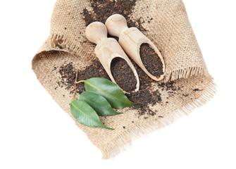 Black tea in wooden scoops isolated on white