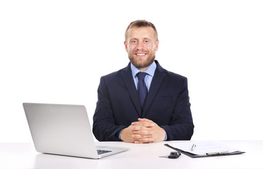 Seller man at table with laptop and car key isolated on white