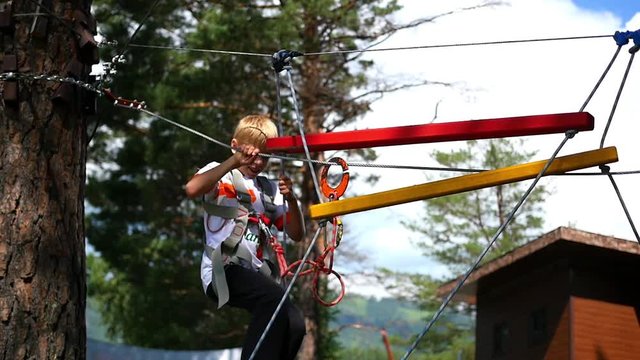 a child climbs on the rope road