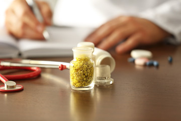 Bottle with dry inflorescence and doctor on background. Herbal medicine concept