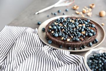 Fototapeta na wymiar Delicious chocolate tart with blueberry and nut on plate