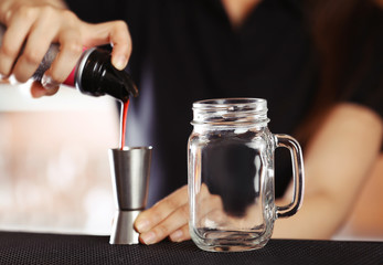 Woman hands making cocktail on bar counter