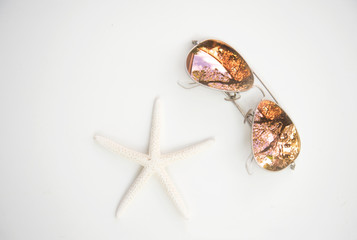 Star fish and glasses on wooden white background, soft focus