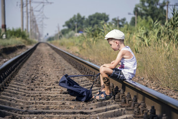 a boy with a backpack traveling by rail