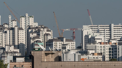 Fototapeta na wymiar View of the typical high-rise apartment blocks and construction cranes in Seoul, South Korea