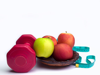 .Red dumbbells weight with measuring tape and  apple