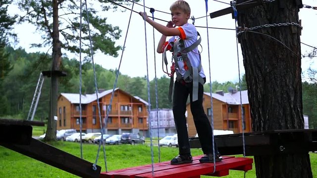a child climbs on the rope road