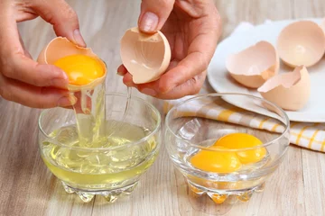 Foto auf Alu-Dibond Frau bricht Ei, um Eiweiß und Eigelb zu trennen © svehlik