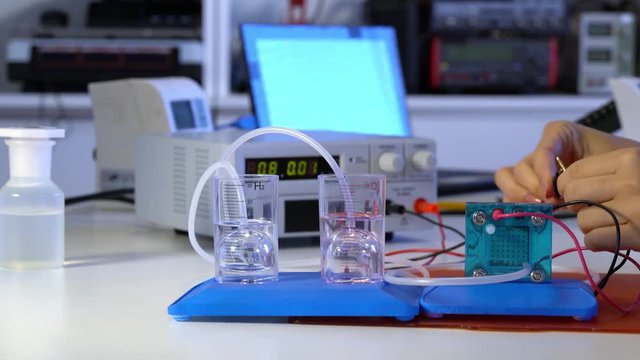 Student teen girl with experiment PEM proton exchange membrane reversible fuel-cell
