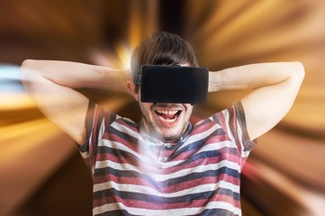 Young happy and excited man is wearing 3D virtual reality glasses and is playing videogames.