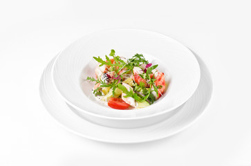 Salad with shrimp, tomatoes, cheese and rocket salad on a plate on a white background
