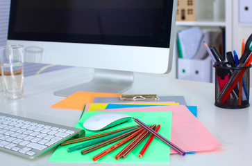 Designer working desk with computer and paperwork