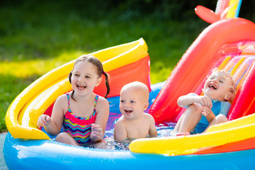 Fototapeta na wymiar Kids playing in inflatable swimming pool