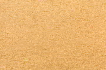 Yellow painted stucco wall. Background texture