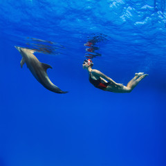 Good relationship with wild animals. Professional swimmer girl in sport swimsuit and friendly...