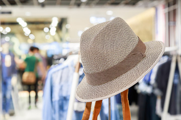 Soft focus brown fashion hat with blurred people shopping in clothes and dress store background