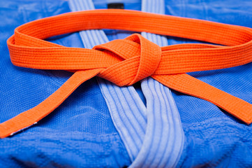 Orange judo belt on blue judo uniform