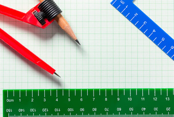 Drawing Compasses and Ruler on green graph paper with copy space