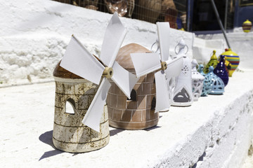 Souvenir wind mils in a row on the whitewashed wall © tolgaildun