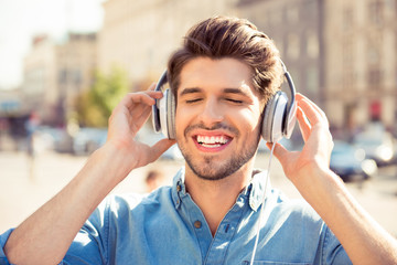 cheerful young man enjoying  music with headphones