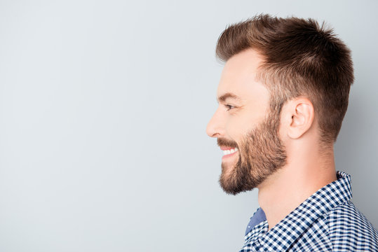 Side view of young happy smiling bearded man
