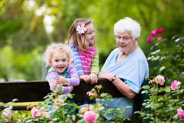 Grandmother and kids sitting in rose garden