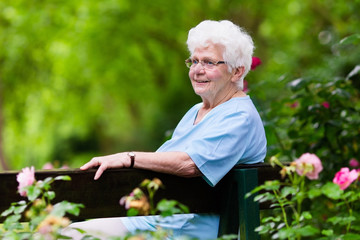 Senior lady in rose garden