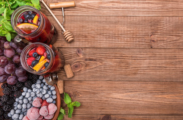 Fototapeta na wymiar Homemade red wine sangria with fresh berries on a wooden table.