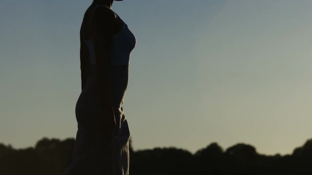 Close shot of african american woman in headscarf walking and enjoying the sunset
