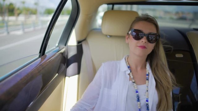 Young woman in sunglasses traveling by car to another city, luxury lifestyle