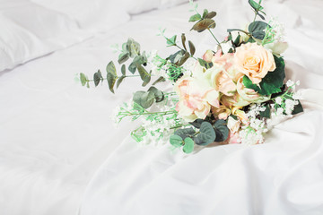 Green and pink wedding bouquet on the bed